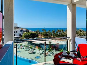 a balcony with a view of a pool and the ocean at Gran Amadores in Amadores