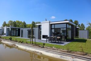 a modern house with a view of a river at EuroParcs Bad Meersee in Nieuwvliet