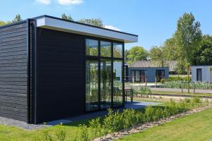 a black clad house in a garden at EuroParcs Bad Meersee in Nieuwvliet