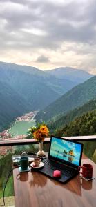 a laptop computer sitting on a wooden table with a view at Yesil Kosk Hotel in Uzungöl