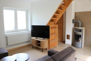 a living room with a tv and a staircase at Kleines Haus am Feld in Rehna