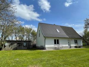 une maison blanche avec une table dans une cour dans l'établissement Kleines Haus am Feld, à Rehna