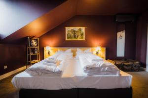 1 dormitorio con 1 cama grande con sábanas blancas y almohadas en Hotel Luis, en Regensburg