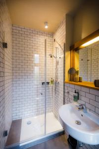 een badkamer met een bad, een wastafel en een douche bij Hotel Luis in Regensburg