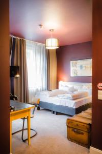 レーゲンスブルクにあるホテル ルイスのベッドルーム1室(ベッド2台、テーブル、デスク付)