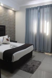a bedroom with a large bed and a window at Bayside Lodge Empangeni in Empangeni