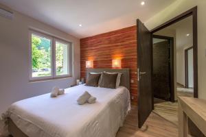 1 dormitorio con 1 cama grande y pared de madera en Le Panoramic - Loft & Mainfloor Outstanding lake View - LLA Selections by Location lac Annecy, en Sévrier