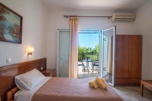 a bedroom with a bed and a balcony at Aleka Apartment 1 in Agios Georgios