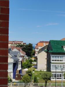 un groupe de maisons avec un toit vert dans l'établissement Apartamento en Somo cerca de la playa totalmente equipado - Somocubas, à Somo