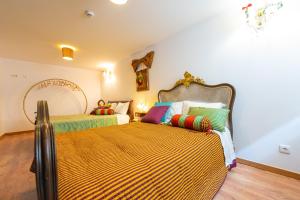 um quarto com 2 camas e almofadas coloridas em Casa do Chefe em Videmonte