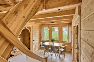 a kitchen and dining room in a log cabin with a table and chairs at Peak House dom wakacyjny z widokiem na Tatry i Giewont in Kościelisko