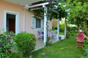 a patio of a house with pink chairs at Jasmine maisonette in Mytikas