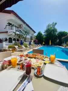 - une table avec des assiettes de nourriture à côté de la piscine dans l'établissement Casablanca Hotel, à Dalyan
