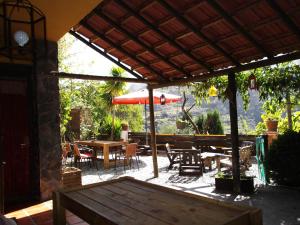 un patio con una mesa y una sombrilla roja en Fundalucia, en Quéntar