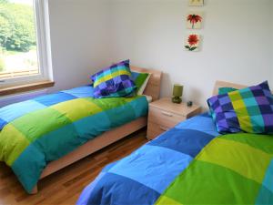 Un dormitorio con dos camas y una ventana. en Annapurna, en Portpatrick