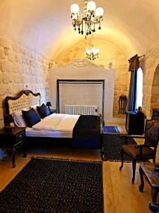a bedroom with a bed and a chandelier at Aslanbey Konağı Butik Otel in Acırlı