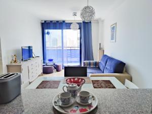 ein Wohnzimmer mit einer Couch und einem Tisch in der Unterkunft ESTRELLA honey apartment in Cala de Finestrat