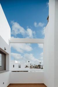 een groot raam in een witte kamer met een blauwe lucht bij La Casita del Poble Nou del Delta in El Poblenou del Delta