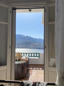 a door to a balcony with a view of the ocean at Astrio Suites in Livadi