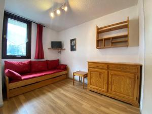 ein Wohnzimmer mit einem roten Sofa und einem Fenster in der Unterkunft Studio Lanslevillard, 1 pièce, 3 personnes - FR-1-508-266 in Lanslevillard