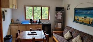 ein Wohnzimmer mit einem Sofa und einem Tisch sowie eine Küche in der Unterkunft Salt River Lodge in Knysna