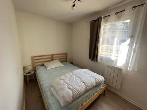 a small bedroom with a bed with a window at Appartement Villard-de-Lans, 2 pièces, 5 personnes - FR-1-515-132 in Villard-de-Lans