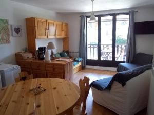 a living room with a wooden table and a kitchen at Studio Corrençon-en-Vercors, 1 pièce, 4 personnes - FR-1-515-140 in Corrençon-en-Vercors