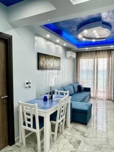 卡尼奧提的住宿－CHANIOTH LUXURY SUITES BY MAKHOME，客厅设有桌子和蓝色天花板