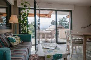 un soggiorno con divano e tavolo di Le Port-Plage residence facing Talloires Beach, LLA Selections by Location lac Annecy a Talloires