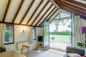 an open living room with a door to a patio at Garden Cottage in Diss