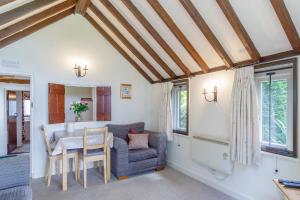 a kitchen and living room with a table and a couch at Garden Cottage in Diss