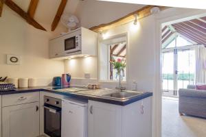 une cuisine avec un évier et un micro-ondes dans l'établissement Garden Cottage, à Diss 11 autres photos