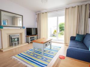 sala de estar con sofá azul y chimenea en 6 Ocean Heights, en Newquay