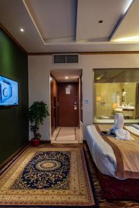a bedroom with a bed with a stuffed animal on it at Luxus Grand Hotel in Lahore