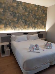 a bedroom with a bed with two babies on it at Hotel NERU con Encanto in León