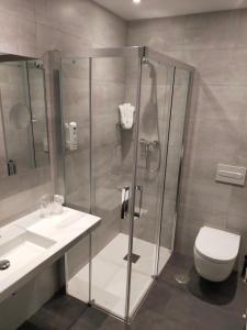 a bathroom with a shower and a toilet and a sink at Hotel NERU con Encanto in León