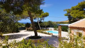 a villa with a swimming pool and a tree at Ponderosa Kefalonia in Lixouri +48 photos