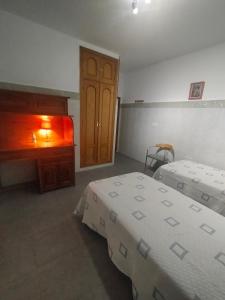 1 dormitorio con 2 camas, vestidor y puerta en Casa Carmen, en Bargas
