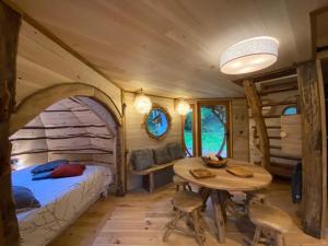 a bedroom in a tiny house with a table and a bed at Les Cabanes De Pyrene in Cazarilh