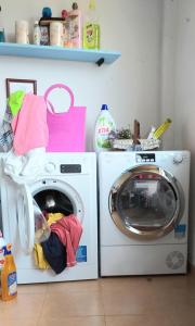 a washing machine and a washer in a room at Páteo memória, casa do beco in Setúbal