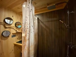 a shower in a bathroom with a shower curtain at Les Cabanes De Pyrene in Cazarilh +136 photos