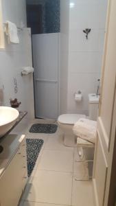 a white bathroom with a toilet and a sink at COPACABANA Praia in Rio de Janeiro