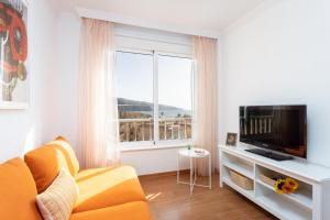 un salon avec un canapé jaune et une télévision dans l'établissement Home2Book Sunny & Quiet Beach House, Pool, à Candelaria