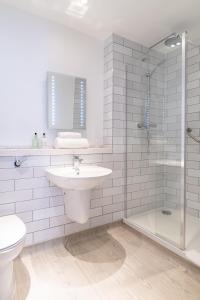 ein weißes Bad mit einem Waschbecken und einer Dusche in der Unterkunft The Hawes Inn by Innkeeper's Collection in Queensferry
