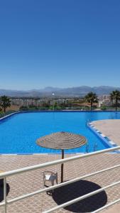 ein großer Pool mit einem Strohschirm in der Unterkunft Cabo dream in Tétouan