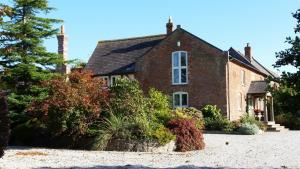 a brick house with plants in front of it at Ty Derw Country House B&B in Ruthin