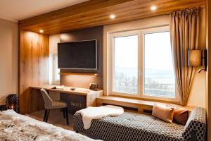 a bedroom with a bed and a desk with a monitor at Burghotel Staufeneck in Salach