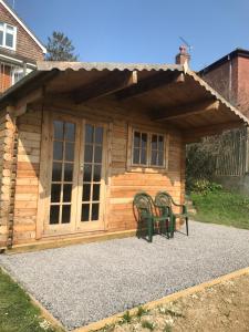 a cabin with two chairs in front of it at Healing Waters Sanctuary for Exclusive Private Hire and Self Catering Board, Vegetarian, Alcohol & Wifi Free Retreat in Glastonbury in Glastonbury