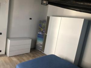 een slaapkamer met een dressoir en een witte koelkast bij Casa il Tramonto del Cilento in Scario