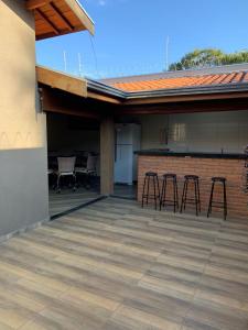 un patio avec des chaises et un bar dans un bâtiment dans l'établissement Casa Thermas Olimpia I - 150 metros do Thermas dos Laranjais, à Olímpia